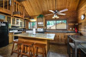 a kitchen with wooden walls and a ceiling fan at Rustic Modern Cabina De Alba in Groveland