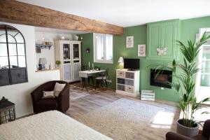 a living room with green walls and a chair at Le Clos de la Chouette in Pommard