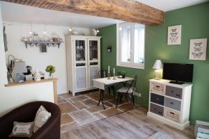 a living room with green walls and a table at Le Clos de la Chouette in Pommard