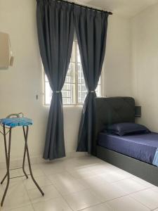 1 dormitorio con 1 cama y una ventana con cortinas en ABSYAR HOMESTAY SELASIH en Putrajaya