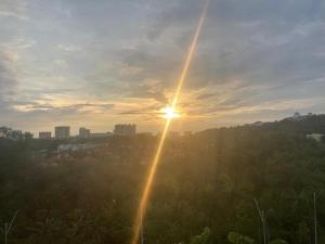 Un sole che tramonta nel cielo sopra una città di ABSYAR HOMESTAY SELASIH a Putrajaya