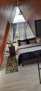 een slaapkamer met een bed en een flatscreen-tv bij GLAMPING Aldea Muisca in Tota