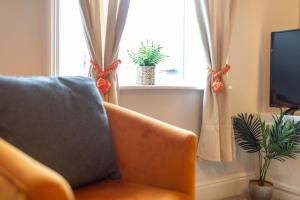 a living room with a couch and a window at Logan House, Modern and Spacious Townhouse close to City Centre in Carlisle