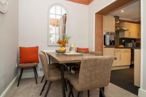 uma cozinha e sala de jantar com uma mesa de madeira e cadeiras em Logan House, Modern and Spacious Townhouse close to City Centre em Carlisle