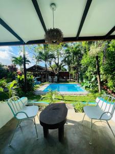 a patio with two chairs and a table and a pool at HOTEL CAREY in Pedasí Town