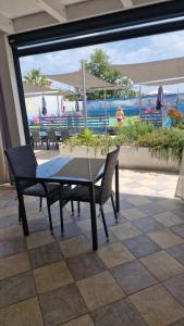 een tafel en stoelen met uitzicht op het strand bij villa oltremare resort in Bagheria