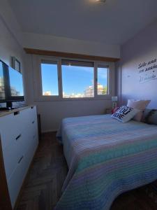 1 dormitorio con 1 cama y TV de pantalla plana en Acogedor departamento 2 amb - Excelente ubicación en Mar del Plata