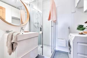a white bathroom with a sink and a mirror at Lovely central apartment with two large bedrooms nearby Oslo Opera, vis a vis Botanical garden in Oslo