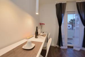 biała jadalnia ze stołem i oknem w obiekcie Guest house D&G -I apartment & room w mieście Zadar
