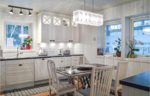 eine Küche mit einem Tisch, Stühlen und einem Kronleuchter in der Unterkunft Awesome Home In Djurhamn With Kitchen in Djurhamn