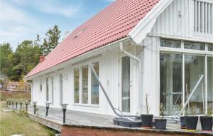 ein weißes Haus mit rotem Dach in der Unterkunft Awesome Home In Djurhamn With Kitchen in Djurhamn
