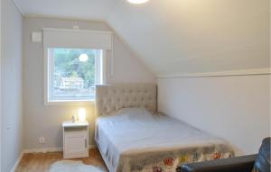 ein kleines Schlafzimmer mit einem Bett und einem Fenster in der Unterkunft Awesome Home In Djurhamn With Kitchen in Djurhamn