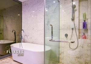 a bathroom with a tub and a glass shower at Flixses Suites at Platinum KLCC in Kuala Lumpur