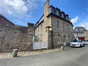 ein Steingebäude mit einem davor geparkt in der Unterkunft Appartement de charme en cœur de ville in Guingamp