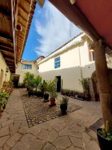 a courtyard with potted plants in front of a building at Anqas Apartment Cusco in Cusco