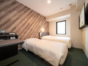 Ein Bett oder Betten in einem Zimmer der Unterkunft Super Hotel Kumamoto Ekimae Natural Hot Springs