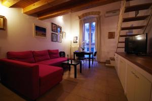 uma sala de estar com um sofá vermelho e uma mesa em Piazzetta Santa Barbara em Bari