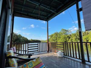 a screened in porch with a view of the water at Hj Hassan Floating Cabin in Kuala Terengganu