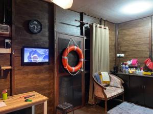 a room with a desk and a chair and a tv at Hj Hassan Floating Cabin in Kuala Terengganu