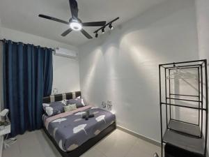 Un dormitorio con una cama y un ventilador de techo. en Desaru Vacation Home KTV-BBQ-Netlfix-Games Near WaterPark, en Kampung Tanjung Agas