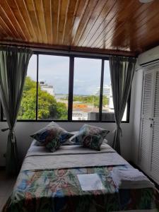 - une chambre avec un lit et une grande fenêtre dans l'établissement Apartahotel Isla Fuerte Piso 4, à Carthagène des Indes