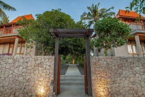 an entrance to a building with a stone fence at Diamond Beach Villas in Nusa Penida