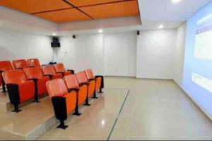 an empty room with orange chairs and a projection screen at CE20 Excepcional Apartamento Piscina y parqueadero in Sabaneta +47 photos