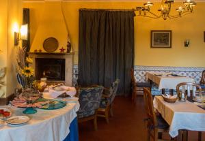 a dining room with two tables and a fireplace at Hotel Sintra Jardim in Sintra