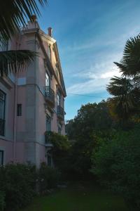 a pink building with a balcony on the side of it at Hotel Sintra Jardim in Sintra