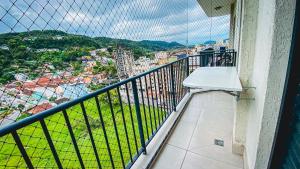 a balcony with a view of a city at APÊ COM PISCINA E AR - 2Q DA PRAIA DA ENSEADA. in Guarujá