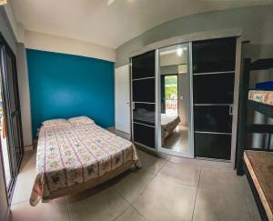 a bedroom with a bed and a blue wall at APÊ COM PISCINA E AR - 2Q DA PRAIA DA ENSEADA. in Guarujá +30 photos
