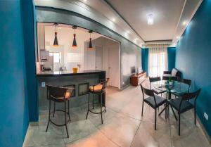 a kitchen and dining room with a table and chairs at APÊ COM PISCINA E AR - 2Q DA PRAIA DA ENSEADA. in Guarujá