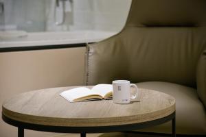 a coffee table with a book and a coffee mug at Spring Rhapsody Hotel in Taichung