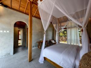 a bedroom with a large bed with a canopy at Diamond Beach Villas in Nusa Penida