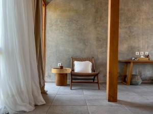 a room with a chair and a table with a pillow at Diamond Beach Villas in Nusa Penida