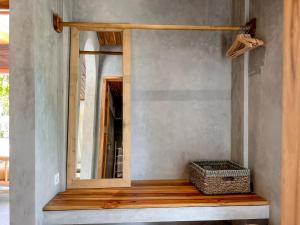 a mirror on a wall next to a wooden bench at Diamond Beach Villas in Nusa Penida