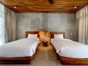 two beds in a room with two lamps at Diamond Beach Villas in Nusa Penida