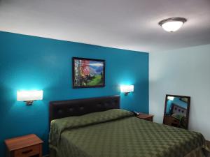 Un dormitorio con una cama y una pared azul. en Budget Inn, en Edinburg