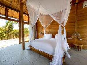 a bedroom with a bed with mosquito net at Diamond Beach Villas in Nusa Penida