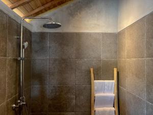 a bathroom with a shower with a chair in it at Diamond Beach Villas in Nusa Penida