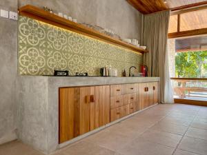 a kitchen with wooden cabinets and a tile floor at Diamond Beach Villas in Nusa Penida
