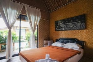1 dormitorio con cama y ventana grande en Moon Bamboo, en Canggu