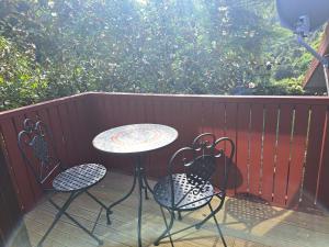 a patio with a table and chairs on a deck at Brightwater Retreat, Tranquil 3bdrm House Near Richmond in Nelson