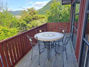 a table and chairs on a deck with a view at Brightwater Retreat, Tranquil 3bdrm House Near Richmond in Nelson