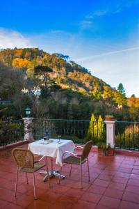 a table and chairs on a patio with a mountain at Hotel Sintra Jardim in Sintra