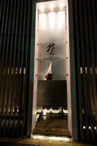 Una puerta a un edificio con un cartel. en HOTELみなと-MINATO- en Tokio