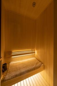 una panchina in una sauna con una luce sopra di HOTELみなと-MINATO- a Tokyo