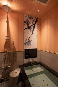 東京的住宿－HOTELみなと-MINATO-，带淋浴的浴室和墙上的电视