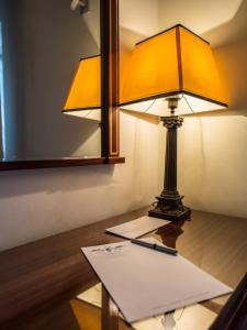 a lamp sitting on top of a table with a paper at Hotel Sintra Jardim in Sintra
