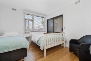 a bedroom with a crib and a window at On The Beach in Rosebud +7 photos